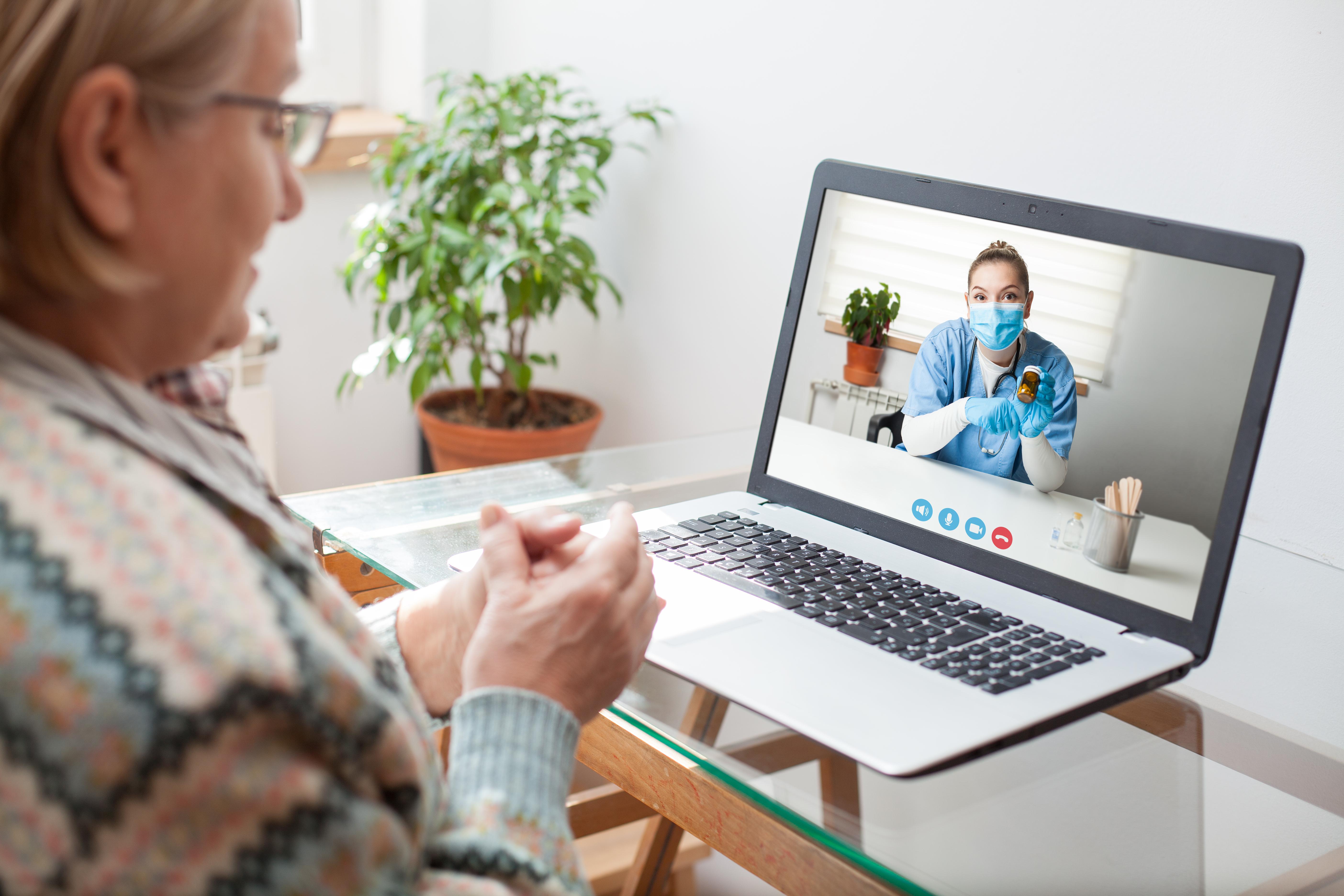 woman videochatting with doctor on a computer image